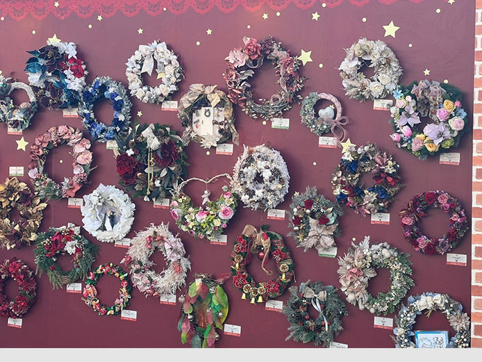 Japanische Weihnachtsdekoration, die an westliche Adventskränze erinnert. Dank der bunten Blumen erhalten sie einen typisch japanischen Touch und bilden einen schönen Mix aus westlicher und japanischer Weihnachtstradition ab.
